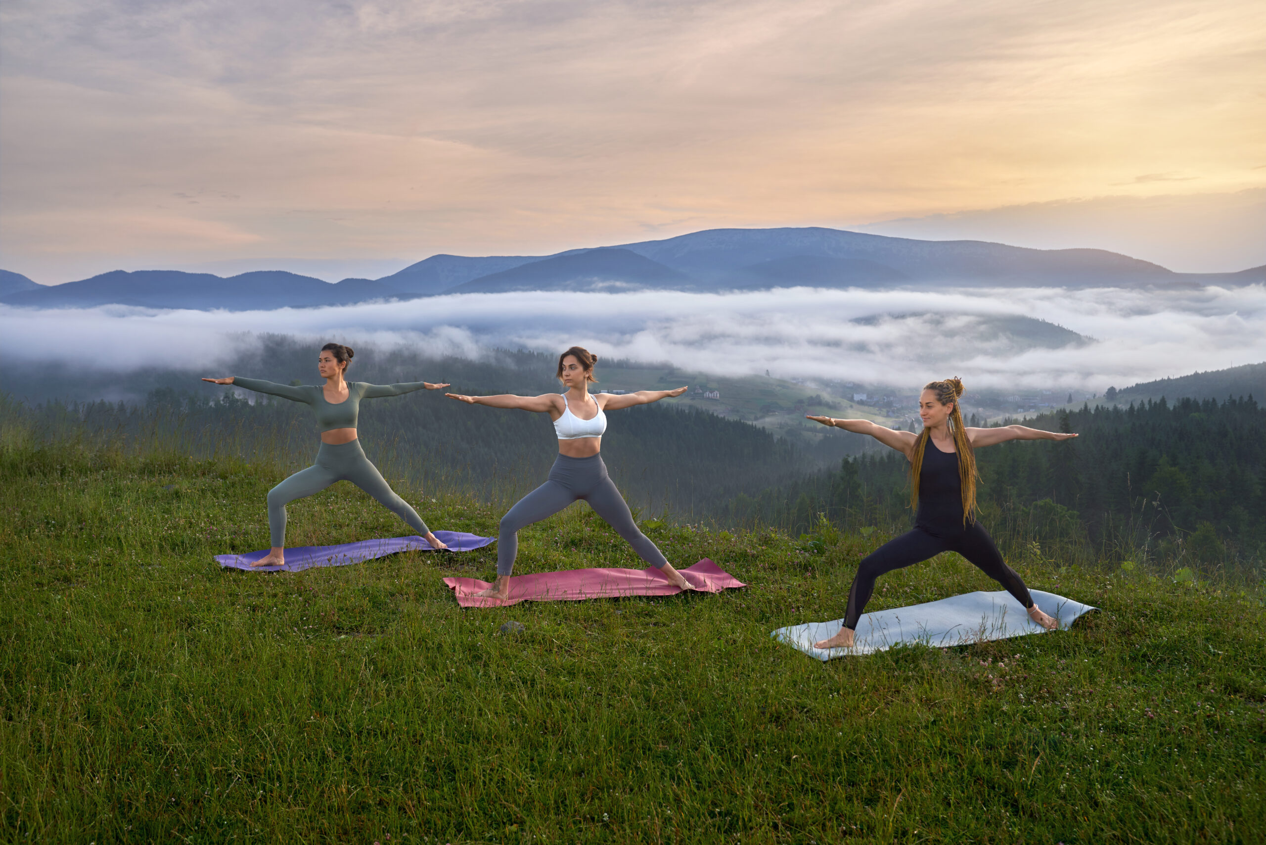 Sporty women doing yoga exercises on nature